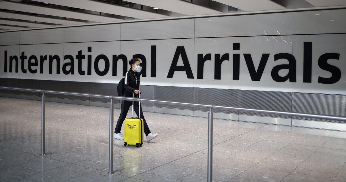 Một hành khách đeo khẩu trang để đề phòng virus corona tại sân bay Heathrow, London - Ảnh: Tolga Akmen/AFP